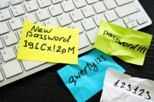 Crumbled up Post-It notes with weak passwords written on them; a new strong password written on a fresh note.